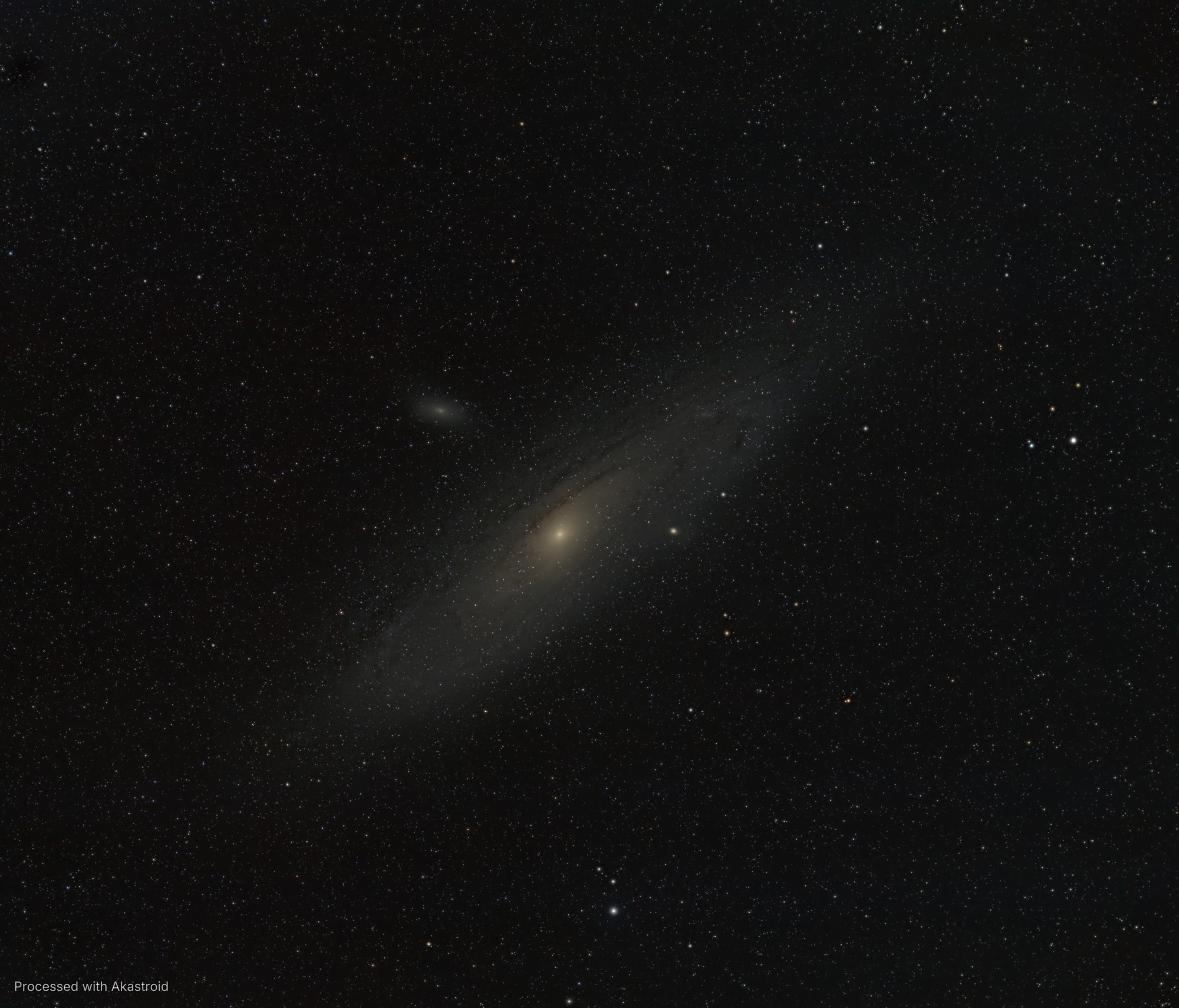 The Andromeda Galaxy with its dust lanes and companion galaxies M32 and M110 in a dense star field, processed in Akastroid