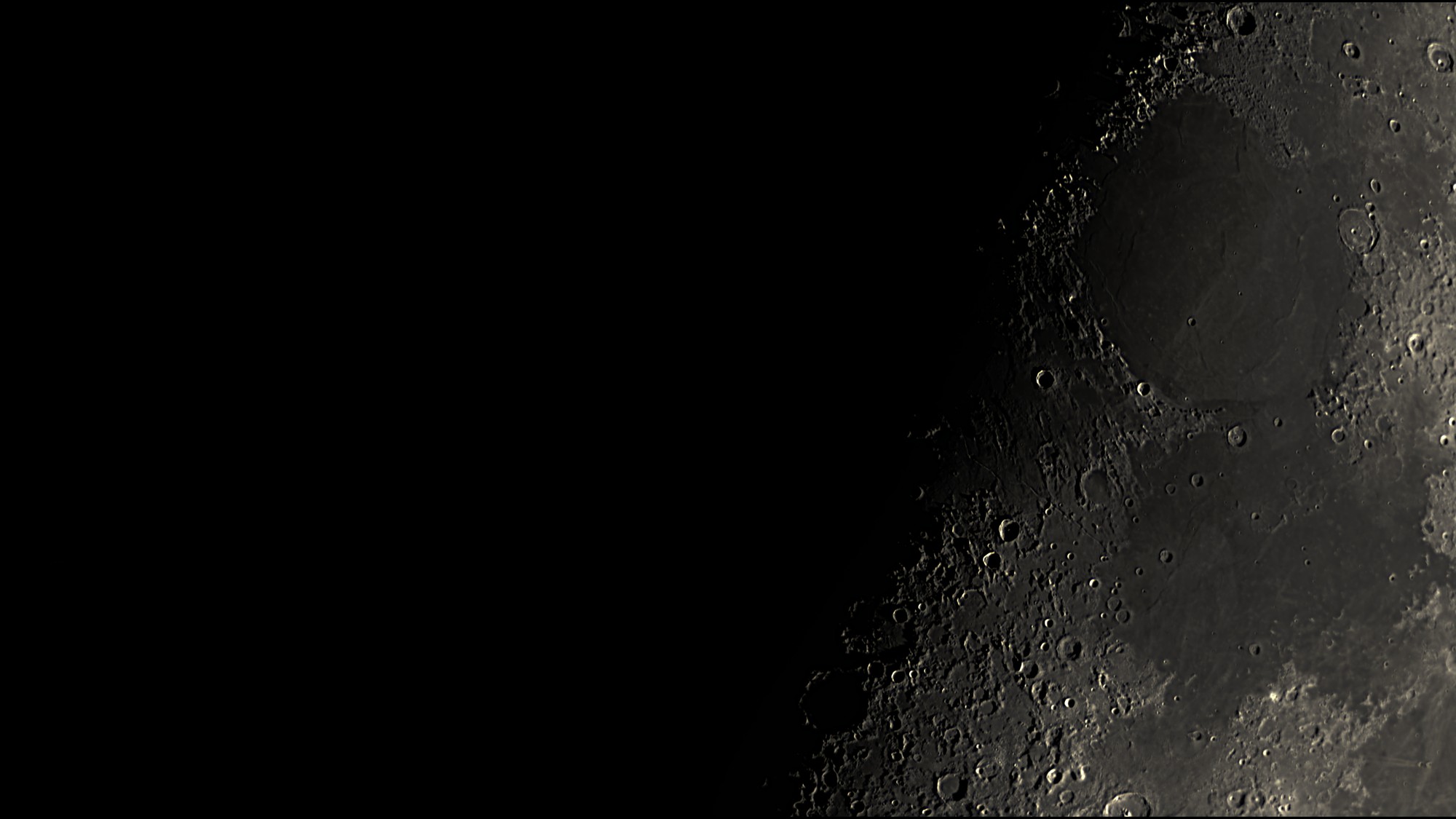 A dark lunar mare along the terminator with craters and ridges in low sunlight, processed in Akastroid